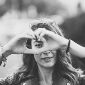 Valentine’s day Girlfriend showing heart-shaped symbol with hands to the camera